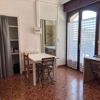 Coin repas et porte fenêtre sur balcon